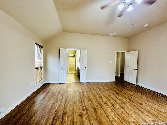 unfurnished bedroom with lofted ceiling, light hardwood / wood-style floors, ceiling fan, and ensuite bathroom