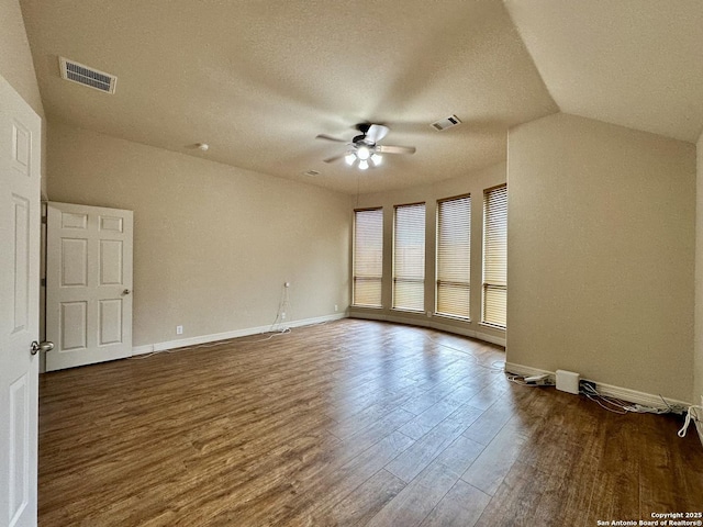 spare room with lofted ceiling, dark hardwood / wood-style floors, a textured ceiling, and ceiling fan