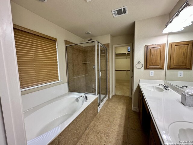 bathroom featuring vanity, tile patterned floors, a textured ceiling, and plus walk in shower