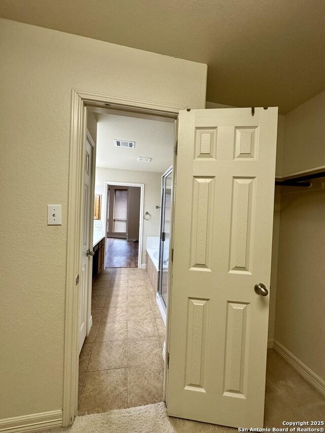 corridor featuring light tile patterned floors