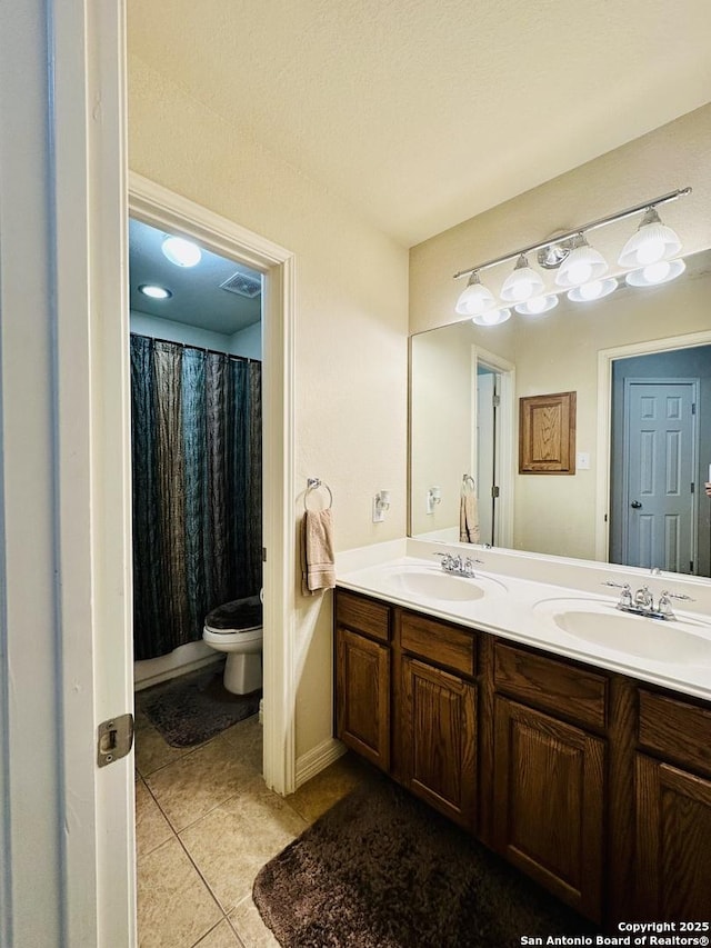 bathroom with tile patterned flooring, vanity, and toilet