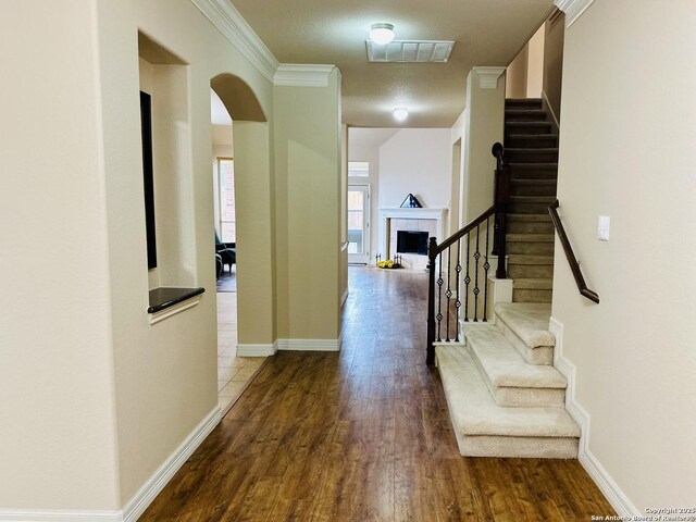 corridor with wood-type flooring and ornamental molding