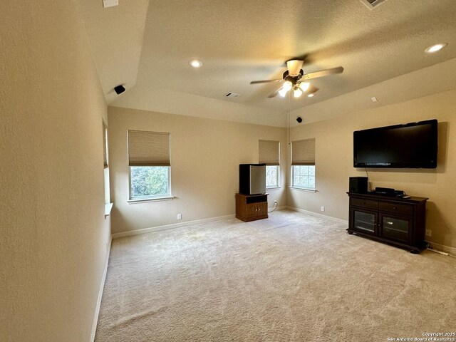 unfurnished living room with ceiling fan, light carpet, and a textured ceiling