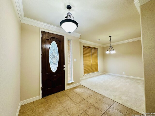 entrance foyer with crown molding, light colored carpet, and a chandelier