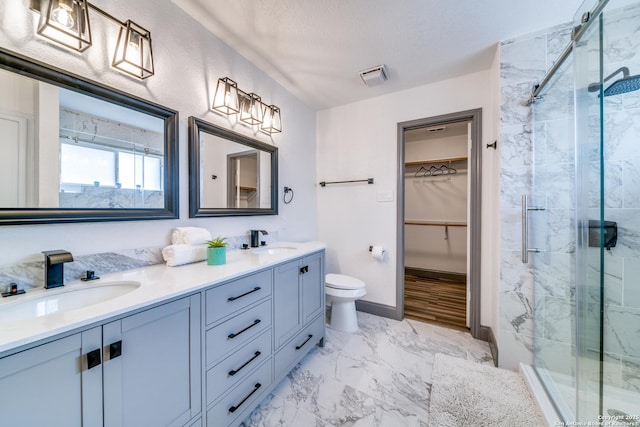 bathroom featuring vanity, toilet, a textured ceiling, and walk in shower