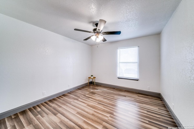 unfurnished room with ceiling fan, light hardwood / wood-style flooring, and a textured ceiling