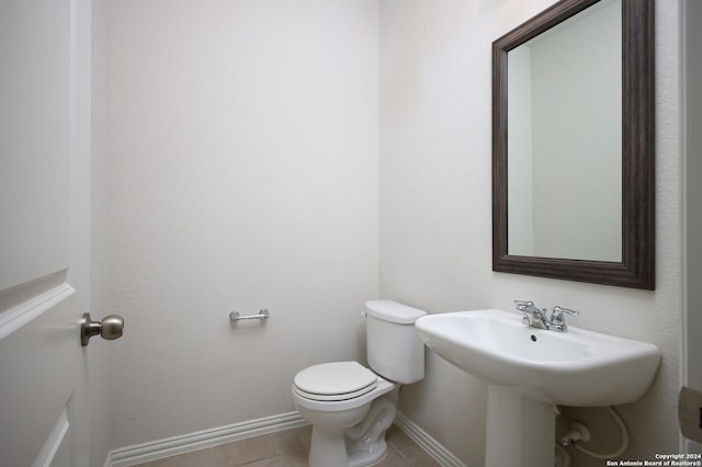 bathroom featuring sink, toilet, and tile patterned flooring