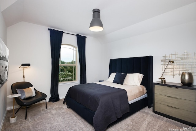 carpeted bedroom with lofted ceiling