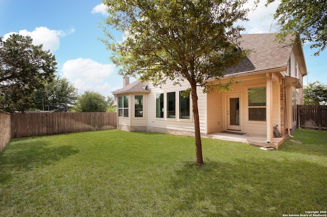 rear view of property with a patio and a yard