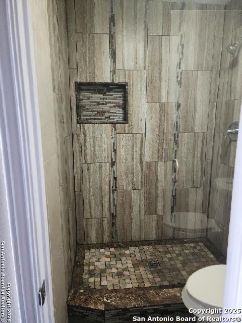 full bathroom with a shower stall and toilet