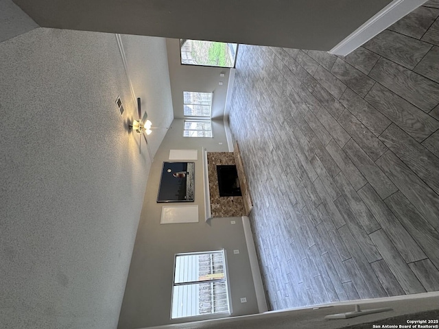 unfurnished living room featuring a towering ceiling, a wealth of natural light, and wood finished floors