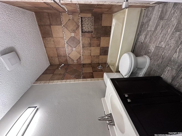 full bath featuring a textured wall and toilet