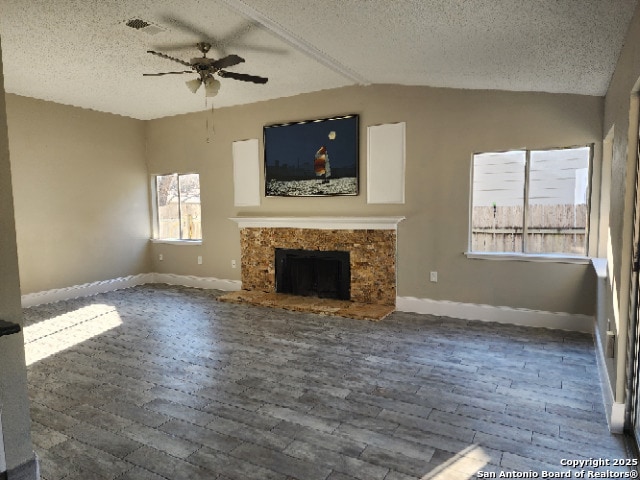 unfurnished living room featuring lofted ceiling, ceiling fan, dark wood-type flooring, and a high end fireplace