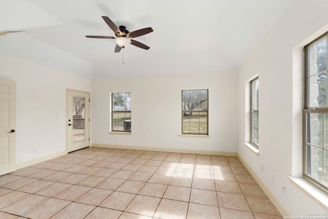 empty room with vaulted ceiling, ceiling fan, and light tile patterned flooring