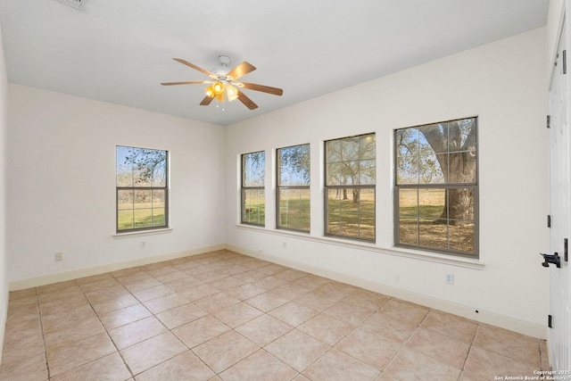 tiled empty room featuring ceiling fan