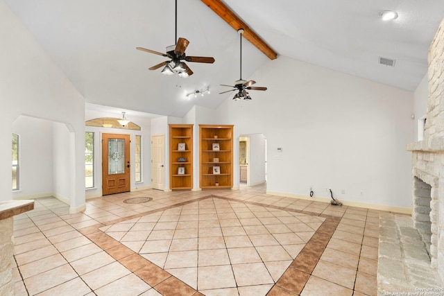 unfurnished living room featuring light tile patterned flooring, a stone fireplace, high vaulted ceiling, and beam ceiling