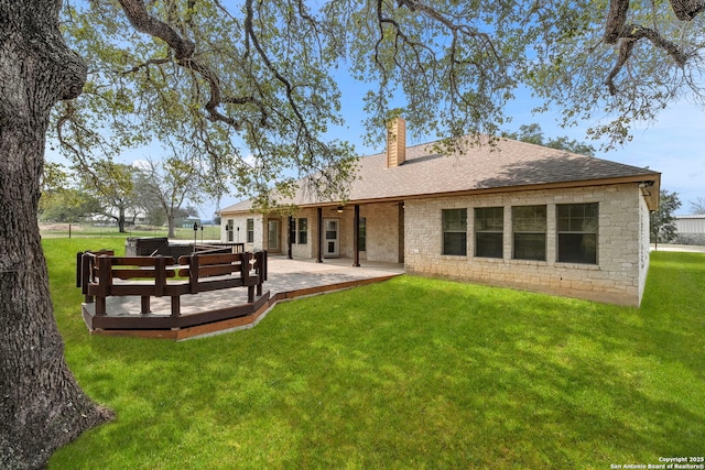 rear view of house with a wooden deck, a yard, and a patio area