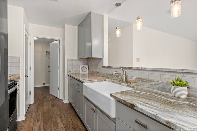 kitchen featuring pendant lighting, gray cabinetry, stainless steel range with electric stovetop, light stone counters, and dark wood-type flooring