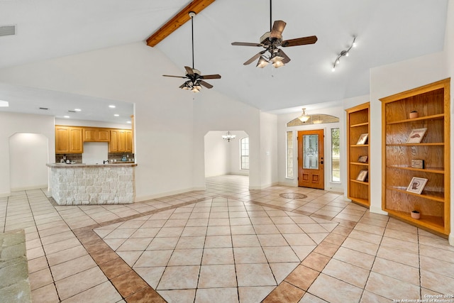 unfurnished living room with light tile patterned flooring, built in shelves, high vaulted ceiling, beam ceiling, and ceiling fan with notable chandelier