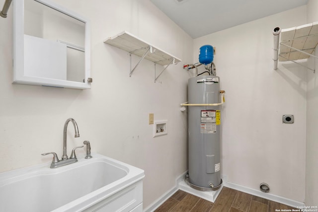 washroom with dark hardwood / wood-style floors, sink, washer hookup, electric water heater, and hookup for an electric dryer