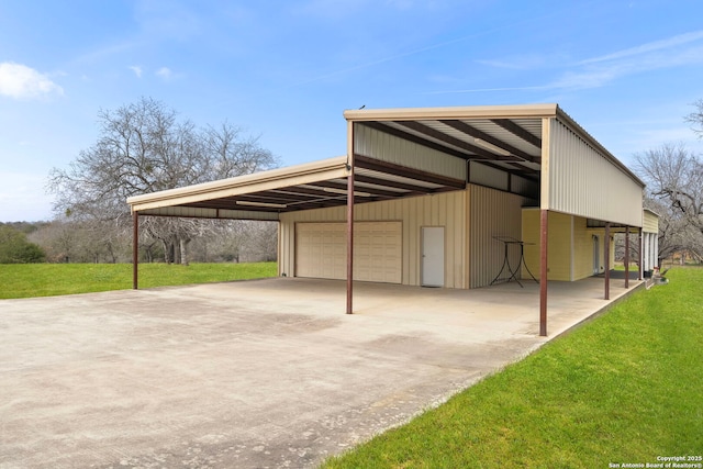 view of outdoor structure featuring a garage, a yard, and a carport