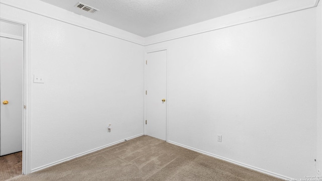 carpeted spare room featuring a textured ceiling