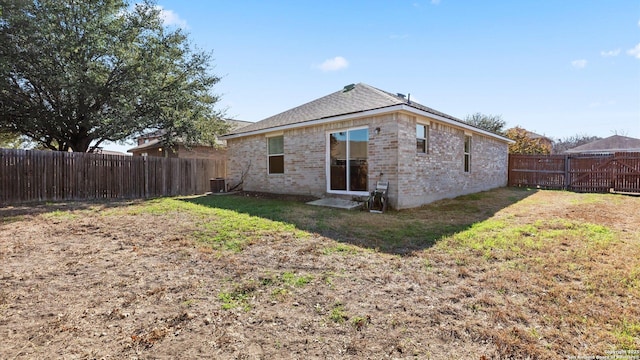 rear view of house with a yard and central AC