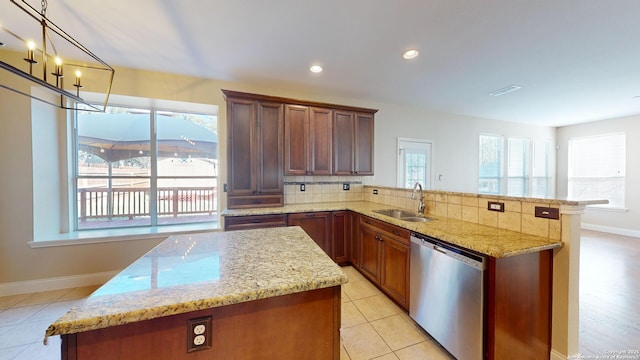 kitchen with sink, decorative backsplash, decorative light fixtures, stainless steel dishwasher, and kitchen peninsula