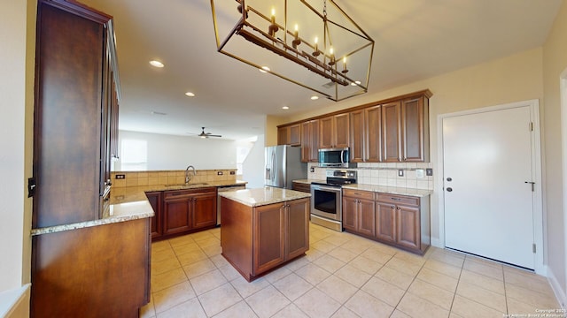 kitchen featuring sink, decorative light fixtures, a center island, kitchen peninsula, and stainless steel appliances