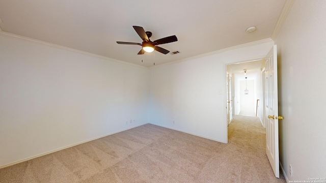 carpeted spare room with ceiling fan and ornamental molding