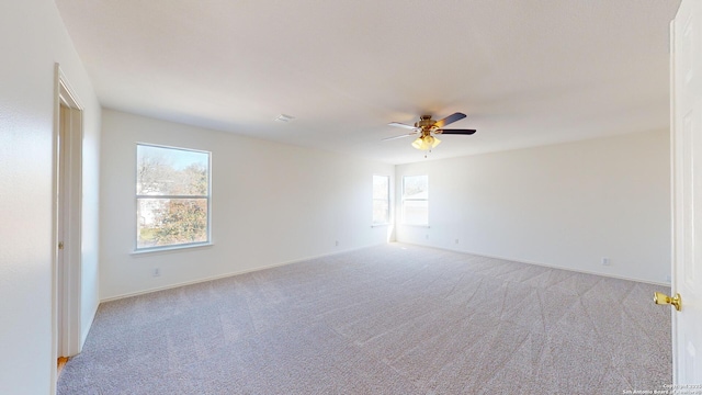 carpeted spare room with ceiling fan