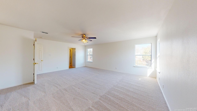 empty room featuring ceiling fan and light colored carpet