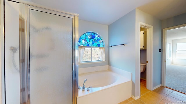 bathroom with tile patterned floors, independent shower and bath, and toilet