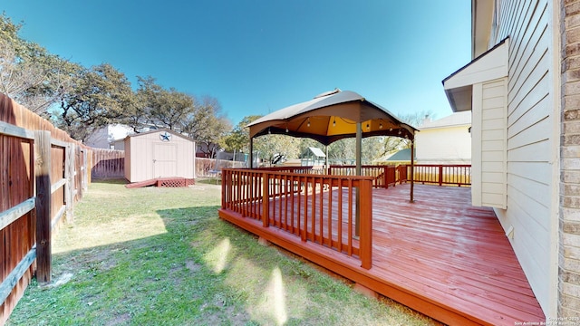 deck with a gazebo, a yard, and a storage shed