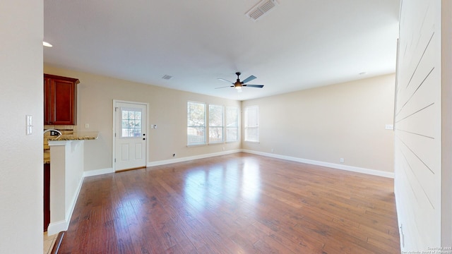 unfurnished living room featuring ceiling fan and wood-type flooring