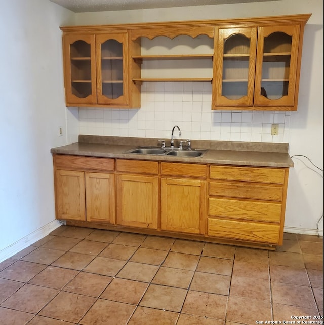 kitchen featuring sink, backsplash, and light tile patterned floors