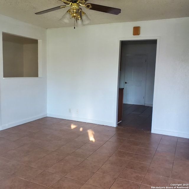 unfurnished room featuring ceiling fan and tile patterned flooring