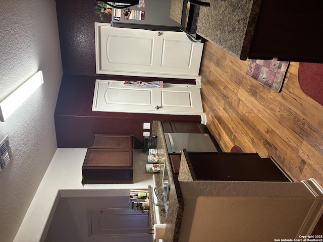 kitchen with white cabinets and wood walls