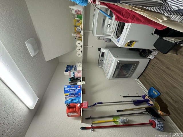 laundry area with stacked washer and clothes dryer and hardwood / wood-style floors