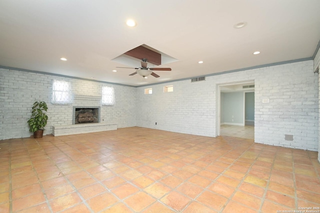 unfurnished living room with light tile patterned flooring, brick wall, ceiling fan, and a brick fireplace