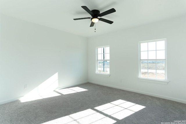 carpeted empty room with ceiling fan and a wealth of natural light