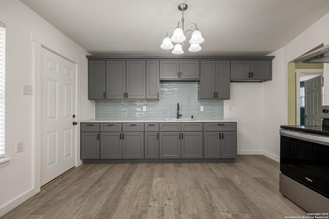 kitchen featuring electric stove, gray cabinets, sink, and light wood-type flooring