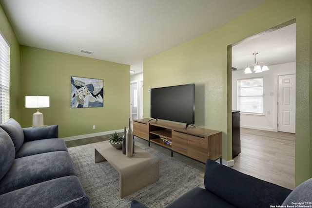 living room with hardwood / wood-style flooring and a notable chandelier