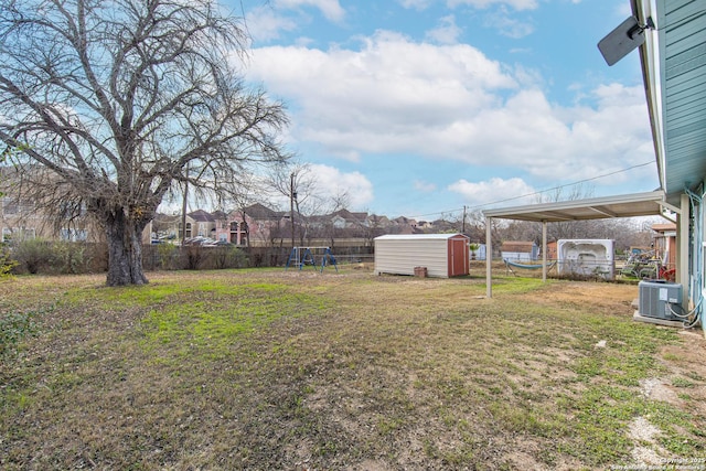 view of yard with a storage unit, central AC unit, and a trampoline