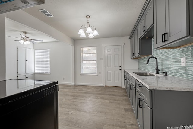 kitchen featuring tasteful backsplash, gray cabinets, and sink