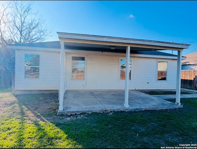 back of property featuring a patio area and a lawn