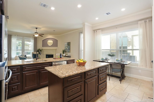 kitchen featuring dark brown cabinetry, sink, crown molding, a center island, and stainless steel dishwasher