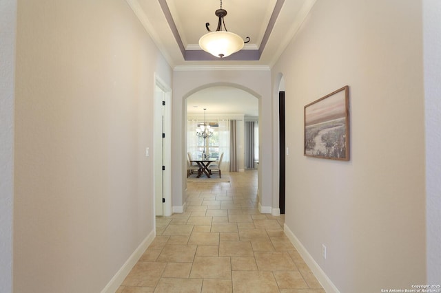 hallway featuring a raised ceiling and ornamental molding