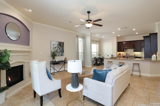 living room with sink, crown molding, and ceiling fan