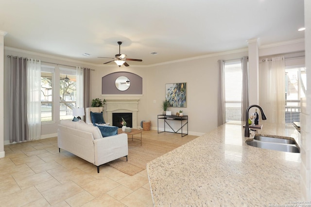 living room with crown molding, sink, and a wealth of natural light